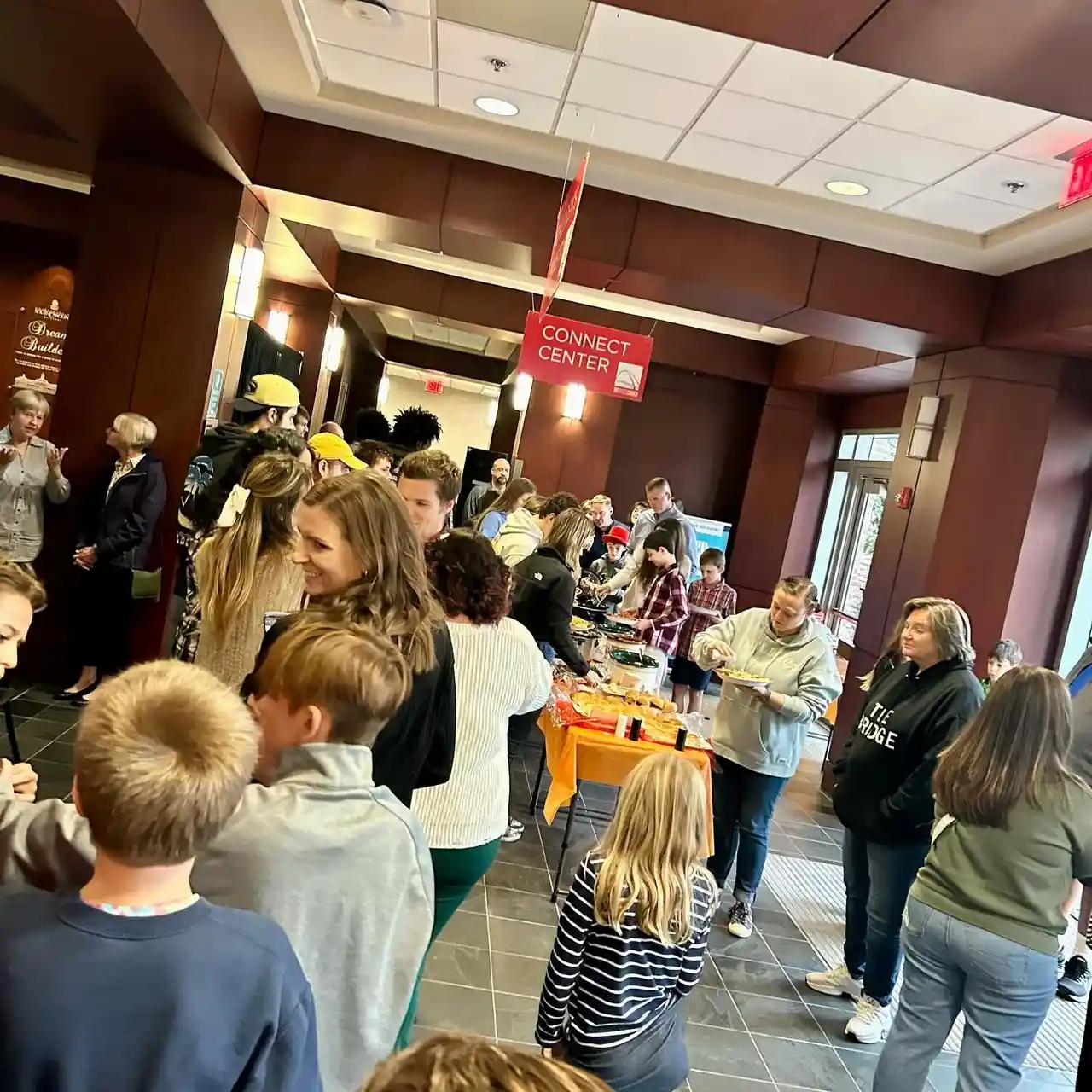 The Bridge Church Connect Center full of people gathering around the welcome table after Sunday service.