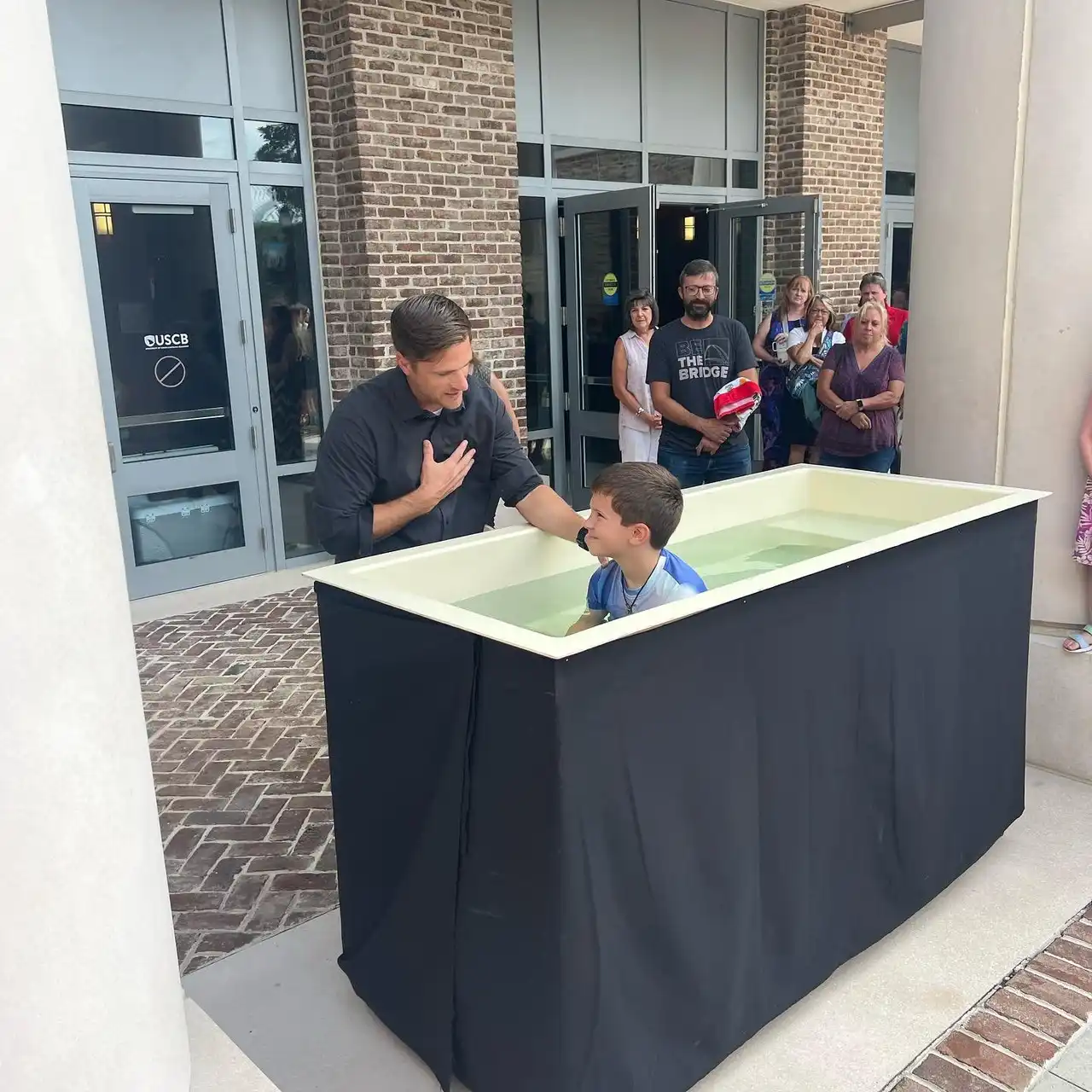 Members of The Bridge Church gather to celebrate a baptism during a Sunday service.