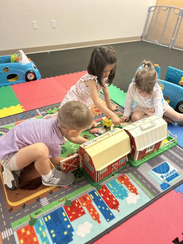 Little ones playing together with a toy farm during Bridge Kids