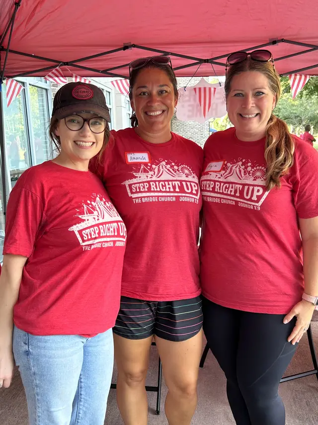 Three Bridge Teams volunteers in matching red shirts at a church event