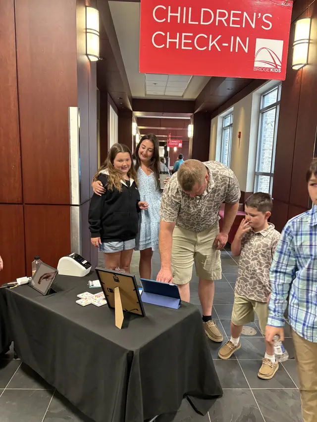 Families checking their kids in at the Children's Check-In station on a Sunday morning