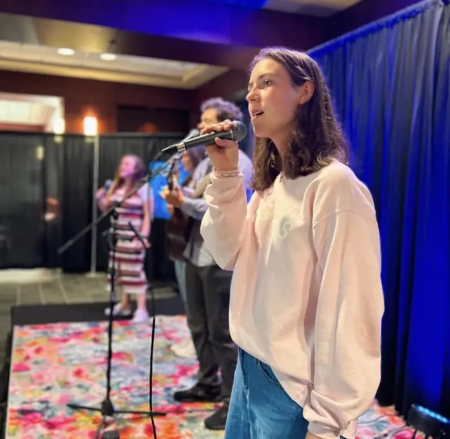A worship team vocalist singing during a Sunday service
